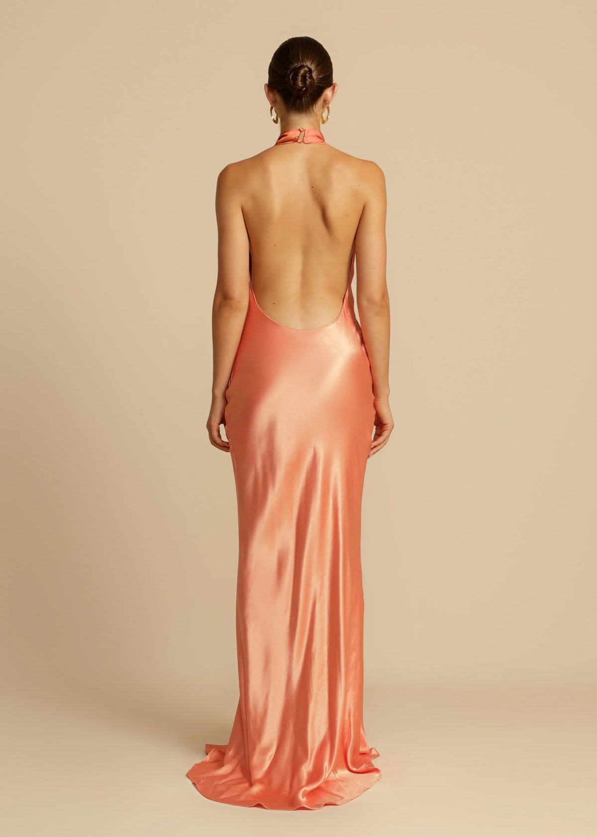 Arcina Ori Gaia Dress Hire in papaya – bias-cut gown with cowl neckline and low open back.