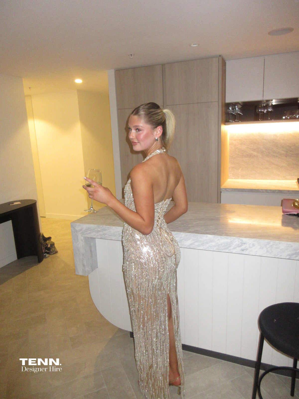 Albina Dyla Stardust Cascade Gown – plunging halter neckline gown with silver bead embellishments, corseted fit, and back leg slit. Hire from Tenn Designer Hire.