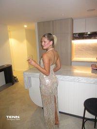 Albina Dyla Stardust Cascade Gown – plunging halter neckline gown with silver bead embellishments, corseted fit, and back leg slit. Hire from Tenn Designer Hire.