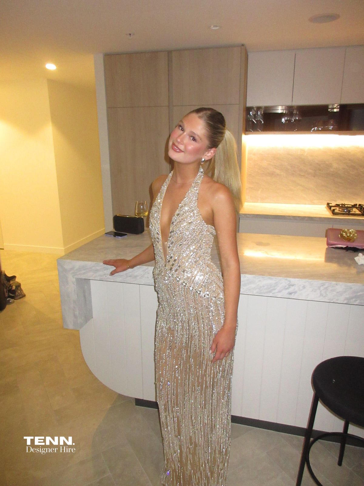 Albina Dyla Stardust Cascade Gown – plunging halter neckline gown with silver bead embellishments, corseted fit, and back leg slit. Hire from Tenn Designer Hire.