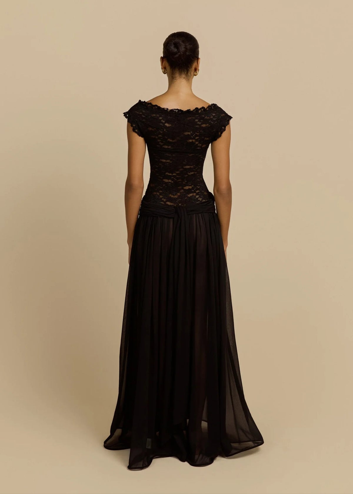 Arcina Ori Arabella Dress available for hire at TENN Designer Hire — unique off-shoulder gown with lace bodice and flowing skirt, perfect for formal events and special occasions, styled with gold accessories.