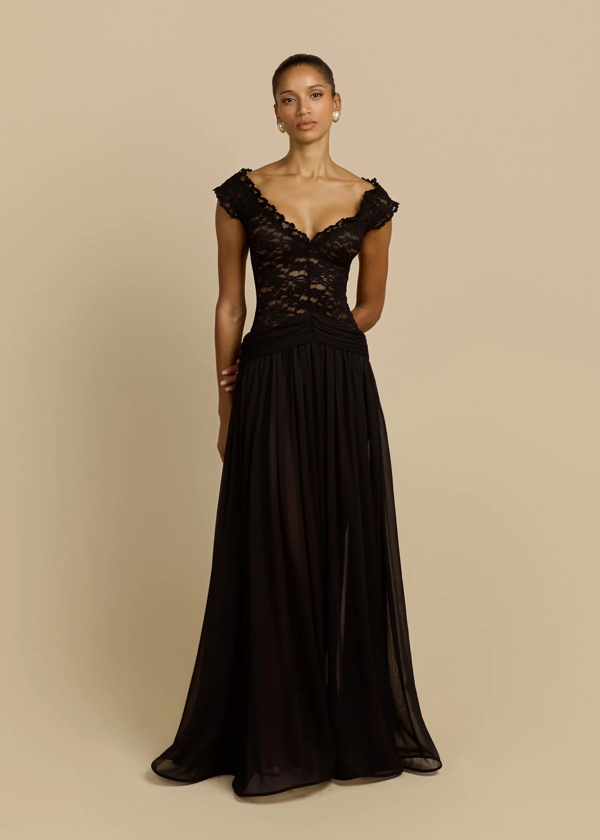 Arcina Ori Arabella Dress available for hire at TENN Designer Hire — unique off-shoulder gown with lace bodice and flowing skirt, perfect for formal events and special occasions, styled with gold accessories.