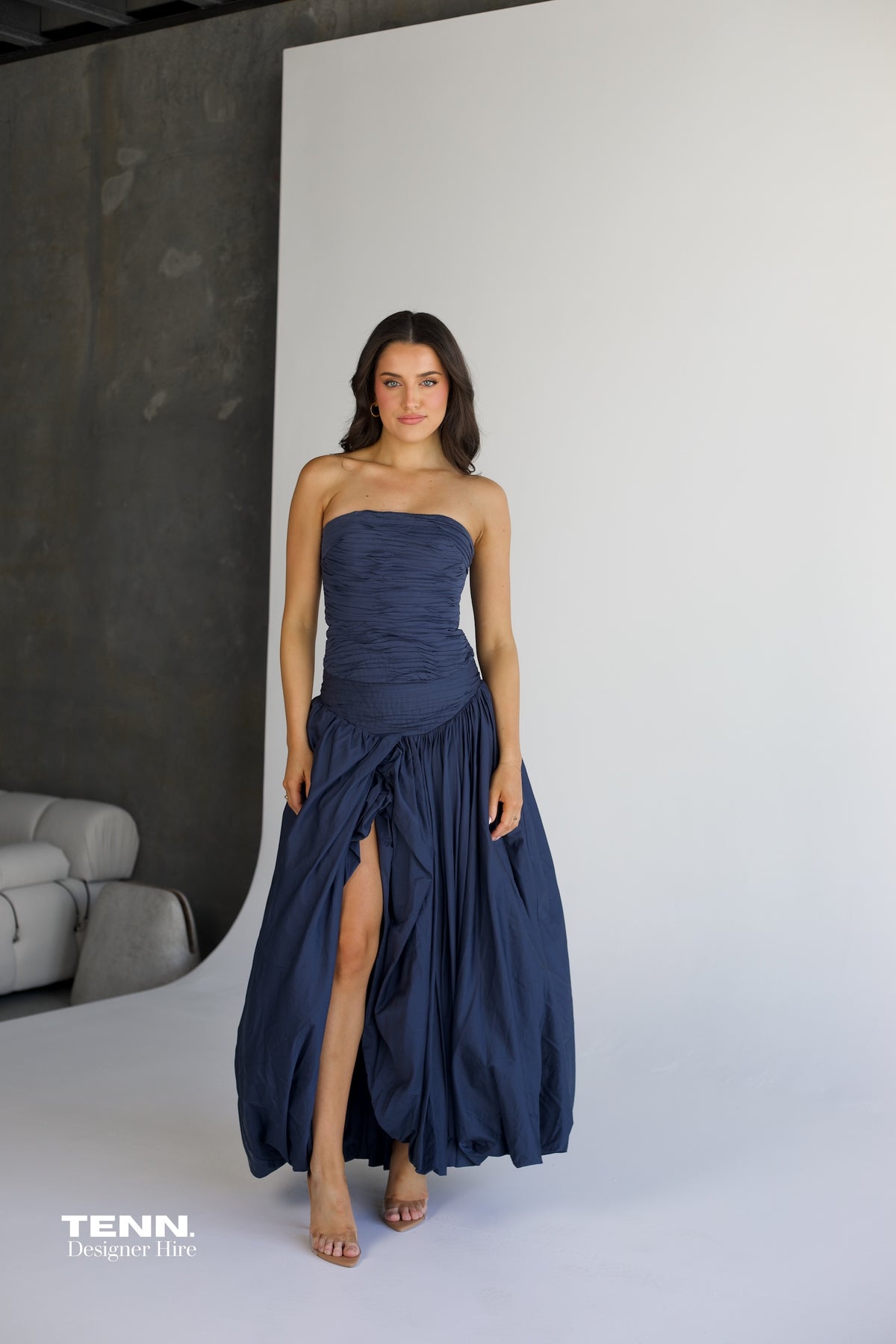 Aje Violette Bubble Hem Maxi Dress in slate available for hire at TENN Designer Hire — two-piece formal gown featuring Sunbeam bustier and Violette bubble hem skirt, thigh-high slit, figure-hugging corset bodice, and elegant dropped waist.