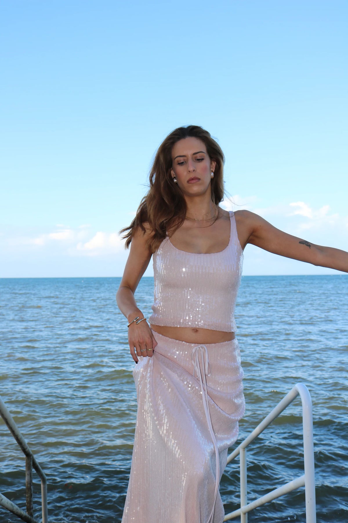 Lane & Sass Aria Cami and Aria Skirt in blush available for hire at TENN Designer Hire — elegant two-piece set featuring soft scoop neckline with subtle shimmer, floaty feminine skirt, elasticated waist, and versatile day-to-night styling options.