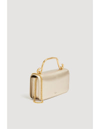 Aje Celeste Flower Clutch featuring a gold top handle and gold sculpted flower detail, photographed against a clean studio backdrop.