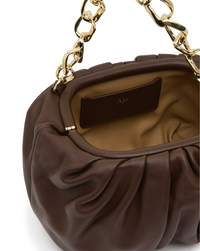 Aje Arden Clutch in brown leather with organic link hardware detailing, luxury designer bag available for hire from TENN Designer Hire.